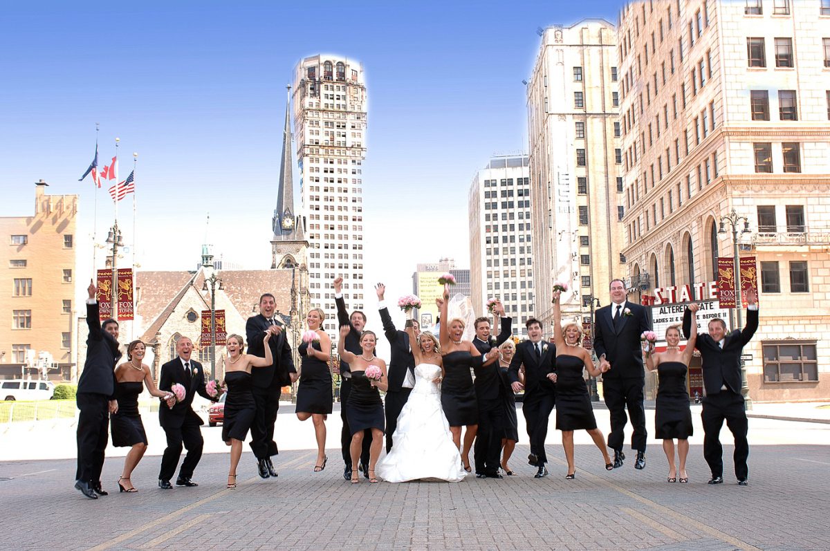 Wedding party jumping in downtown street